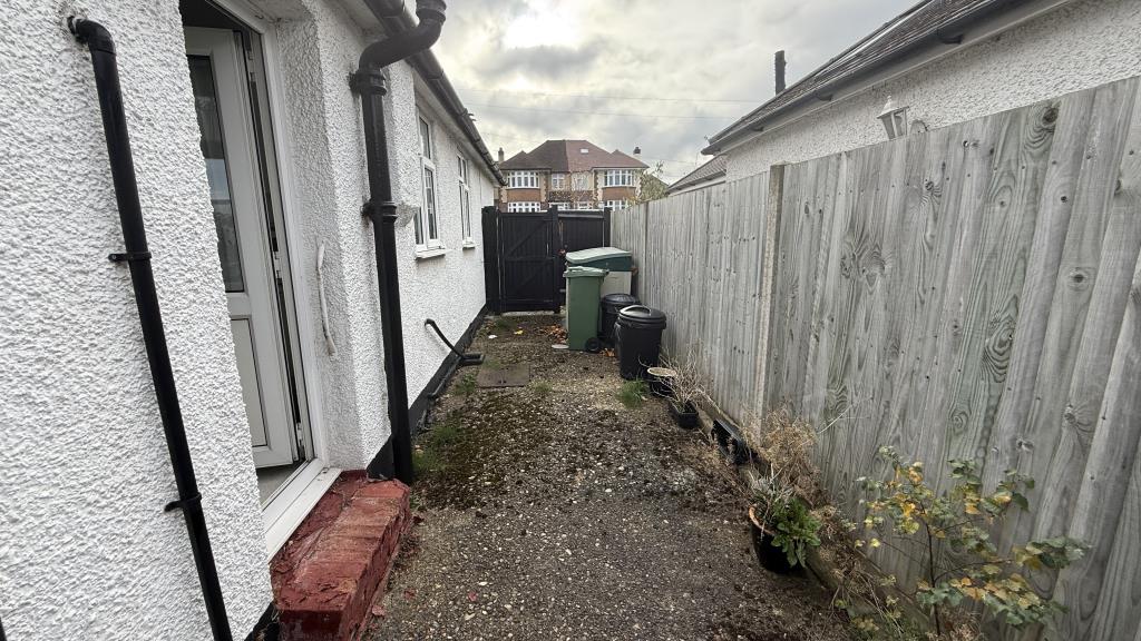Lot: 62 - SEMI-DETACHED BUNGALOW WITH POTENTIAL - External image of side access from kitchen door area towards front